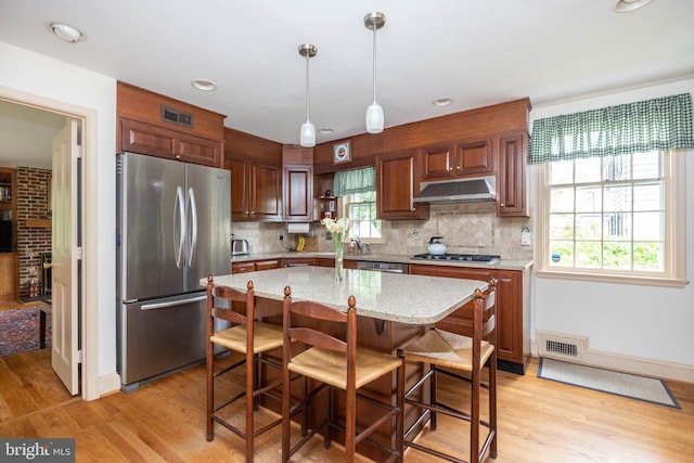 114 Bellemore Rd, Baltimore, MD 21210 - kitchen featuring appliances with stainless steel finishes, under cabinet range hood, backsplash, light wood-style flooring, and recessed lighting