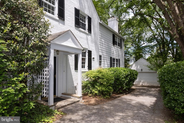 114 Bellemore Rd, Baltimore, MD 21210 - entrance to property with a chimney, a detached garage, and brick siding