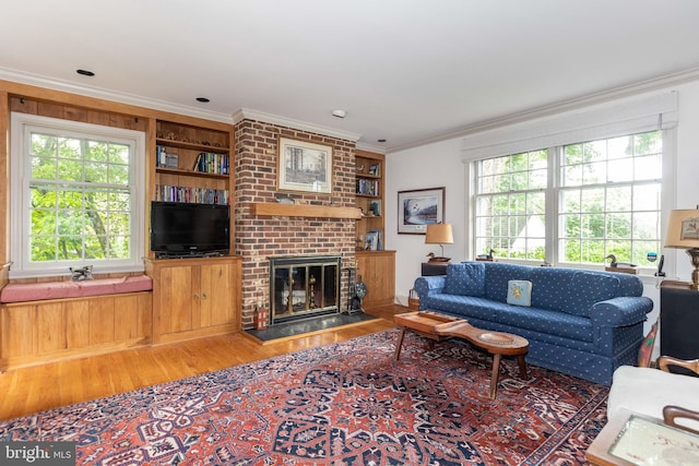 114 Bellemore Rd, Baltimore, MD 21210 - living room featuring wood finished floors, crown molding, plenty of natural light, a fireplace, and built in shelves