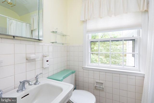 114 Bellemore Rd, Baltimore, MD 21210 - bathroom featuring a sink, tile walls, toilet, and a shower with curtain