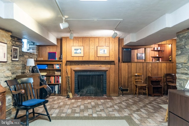 114 Bellemore Rd, Baltimore, MD 21210 - living room with rail lighting, wooden walls, and a brick fireplace