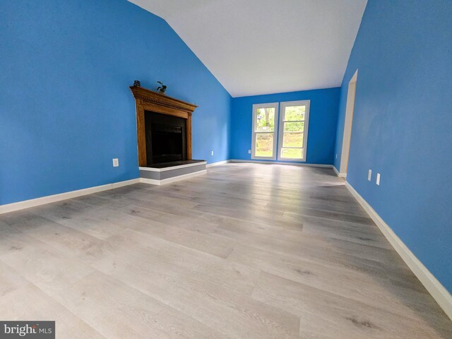 10920 Oakcrest Cir, New Market, MD 21774 - unfurnished living room featuring lofted ceiling, a fireplace with raised hearth, wood finished floors, and baseboards