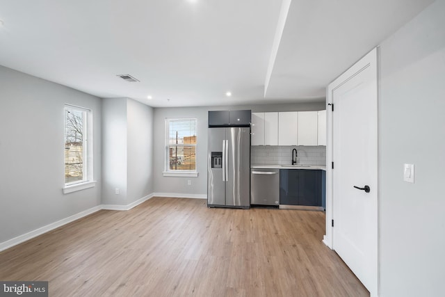 2639 Cecil B Moore Ave, Philadelphia, PA 19121 - kitchen featuring appliances with stainless steel finishes, a sink, light wood-style floors, light countertops, and backsplash