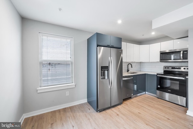 2639 Cecil B Moore Ave, Philadelphia, PA 19121 - kitchen featuring stainless steel appliances, light wood-style floors, light countertops, backsplash, and baseboards