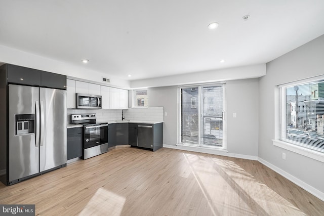 2639 Cecil B Moore Ave, Philadelphia, PA 19121 - kitchen featuring appliances with stainless steel finishes, a sink, light countertops, backsplash, and light wood-type flooring
