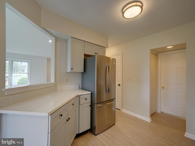 9309 Player Dr Unit 116, Laurel, MD 20708 - kitchen with freestanding refrigerator, light wood finished floors, baseboards, and light stone countertops
