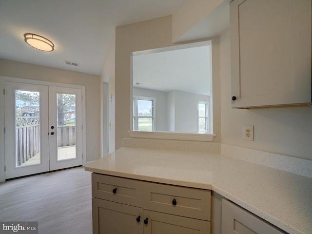 9309 Player Dr Unit 116, Laurel, MD 20708 - kitchen with french doors, light stone counters, light wood-type flooring, and a peninsula