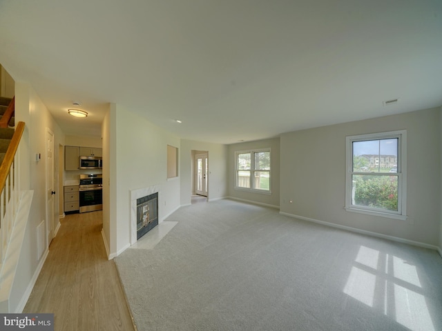 9309 Player Dr Unit 116, Laurel, MD 20708 - unfurnished living room with a fireplace, baseboards, stairs, and light wood finished floors