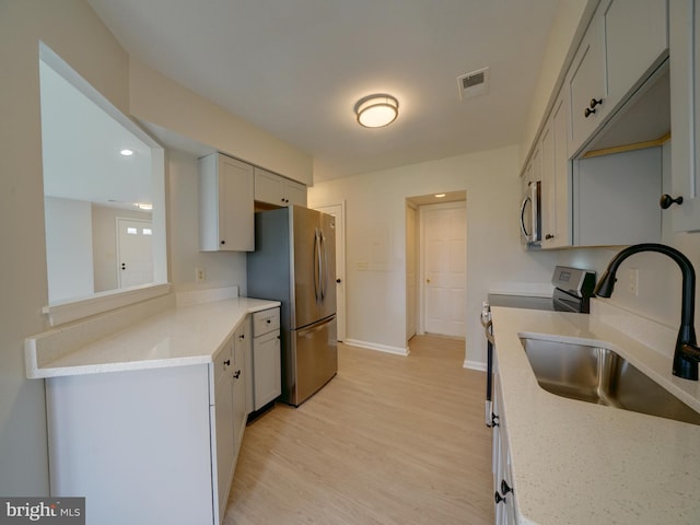 9309 Player Dr Unit 116, Laurel, MD 20708 - kitchen featuring stainless steel appliances, a sink, baseboards, light wood-style floors, and light stone counters