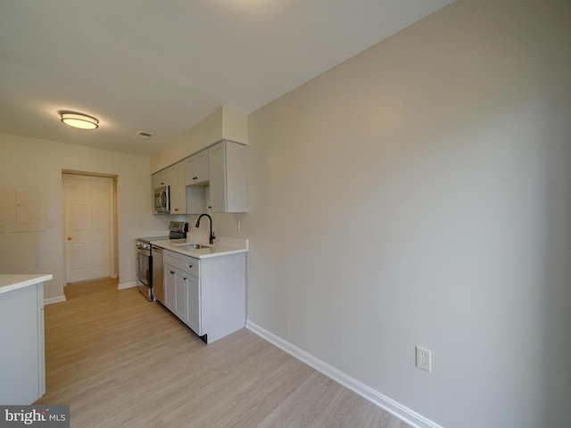 9309 Player Dr Unit 116, Laurel, MD 20708 - kitchen with appliances with stainless steel finishes, a sink, baseboards, light wood-style floors, and light countertops