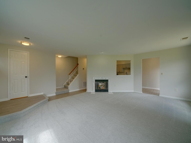 9309 Player Dr Unit 116, Laurel, MD 20708 - unfurnished living room with light colored carpet, a fireplace, baseboards, and stairs