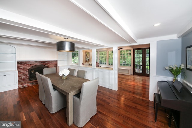 3195 Pelham Pl, Doylestown, PA 18902 - dining area featuring dark wood-style flooring, a brick fireplace, healthy amount of natural light, wainscoting, and beam ceiling