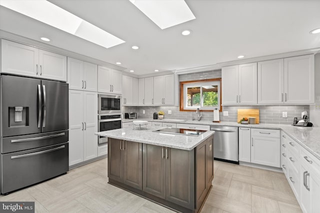10060 Hampton Rd, Fairfax Station, VA 22039 - kitchen with stainless steel appliances, a skylight, white cabinets, tasteful backsplash, and recessed lighting