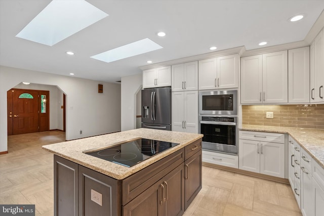10060 Hampton Rd, Fairfax Station, VA 22039 - kitchen with stainless steel appliances, a skylight, white cabinetry, tasteful backsplash, and recessed lighting