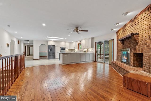 10060 Hampton Rd, Fairfax Station, VA 22039 - unfurnished living room with a ceiling fan, light wood finished floors, a brick fireplace, and recessed lighting