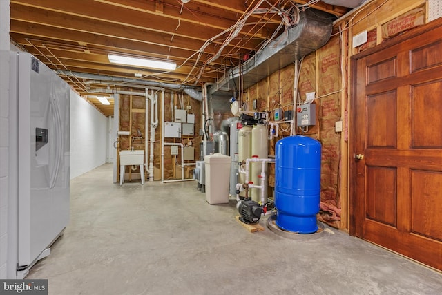 10060 Hampton Rd, Fairfax Station, VA 22039 - unfinished below grade area featuring a water pressure tank, white fridge with ice dispenser, and a water softener