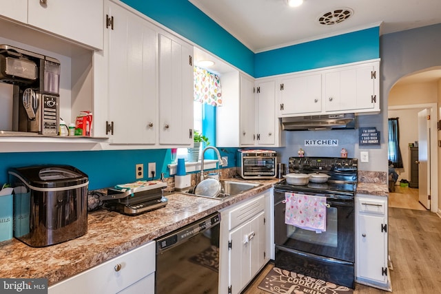 935 Grove St, Reading, PA 19605 - kitchen featuring black appliances, under cabinet range hood, a sink, arched walkways, and white cabinets