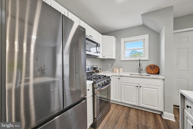 1076 Tunbridge Rd, Baltimore, MD 21212 - kitchen with appliances with stainless steel finishes, a sink, dark wood finished floors, white cabinets, and lofted ceiling