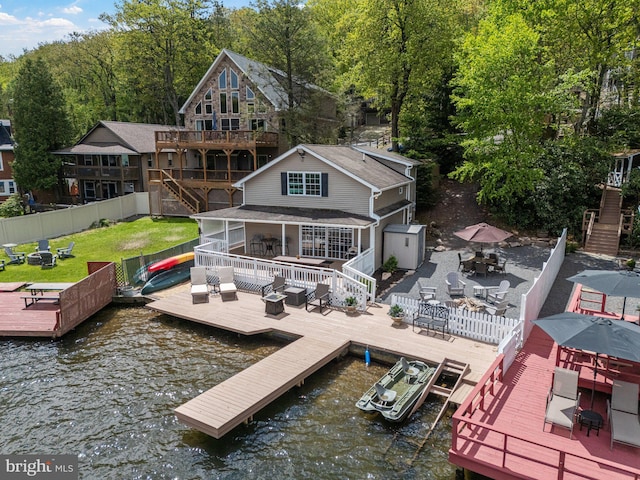 34 S Lake Dr, Lake Harmony, PA 18624 - rear view of property featuring a deck with water view, a fenced backyard, outdoor dining area, stairs, and an outdoor hangout area