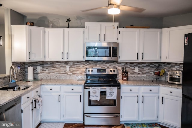 9348 Amaryllis Ave, Manassas, VA 20110 - kitchen with appliances with stainless steel finishes, a sink, white cabinetry, and light stone counters