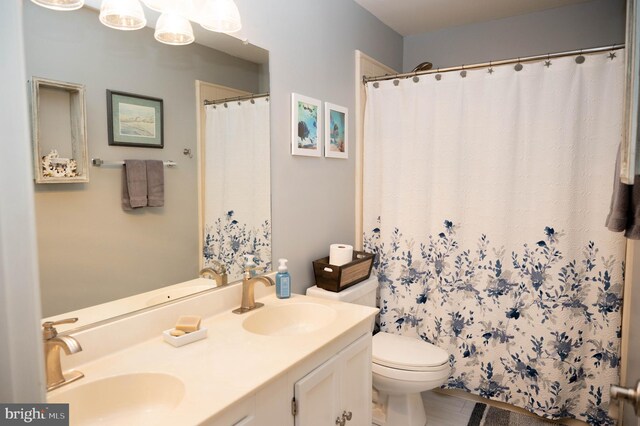 9348 Amaryllis Ave, Manassas, VA 20110 - full bathroom with double vanity, toilet, and curtained shower