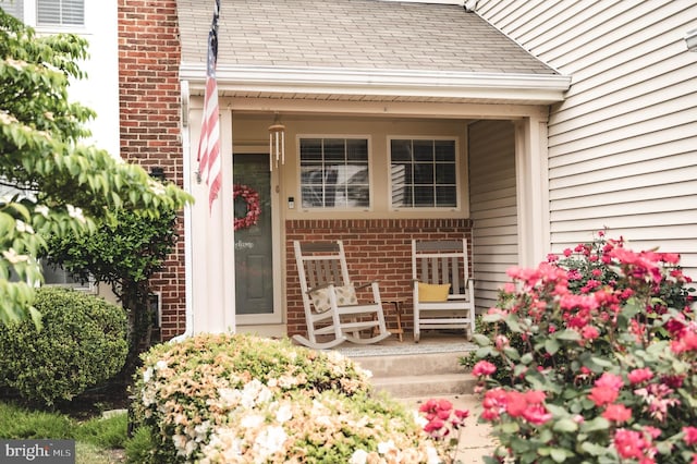 9348 Amaryllis Ave, Manassas, VA 20110 - view of exterior entry with brick siding, a porch, and roof with shingles