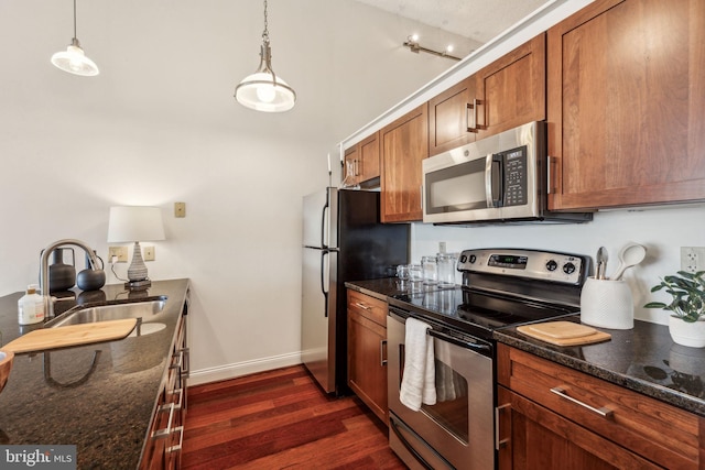 2429 Locust St Unit 504, Philadelphia, PA 19103 - kitchen featuring stainless steel appliances, a sink, dark wood-style floors, brown cabinetry, and lofted ceiling