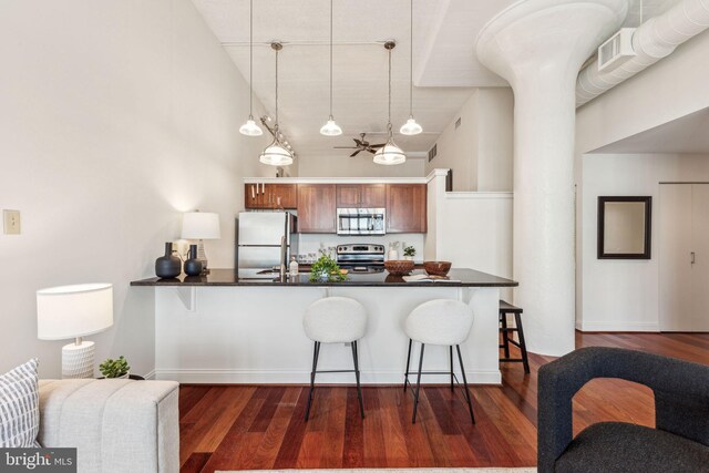 2429 Locust St Unit 504, Philadelphia, PA 19103 - kitchen with appliances with stainless steel finishes, dark countertops, a kitchen breakfast bar, high vaulted ceiling, and a peninsula