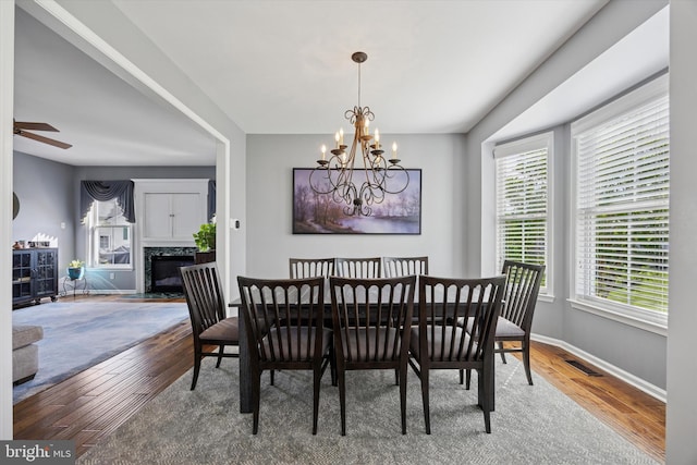 246 Honey Hollow Ln, Chalfont, PA 18914 - dining area with wood finished floors, a chandelier, baseboards, a fireplace, and ceiling fan