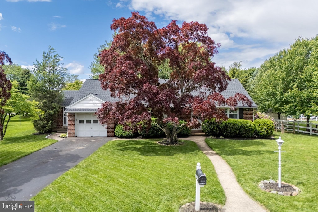 1050 Westgate Dr, Bethlehem, PA 18017 - view of property hidden behind natural elements featuring brick siding, asphalt driveway, a garage, and a shingled roof