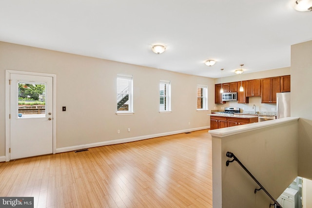 3318 Sherman Ave NW Unit 104, Washington, DC 20010 - kitchen featuring stainless steel appliances, brown cabinets, healthy amount of natural light, and light countertops