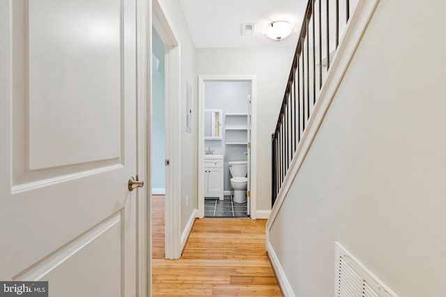 3318 Sherman Ave NW Unit 104, Washington, DC 20010 - hall featuring light wood-style flooring, stairs, and baseboards