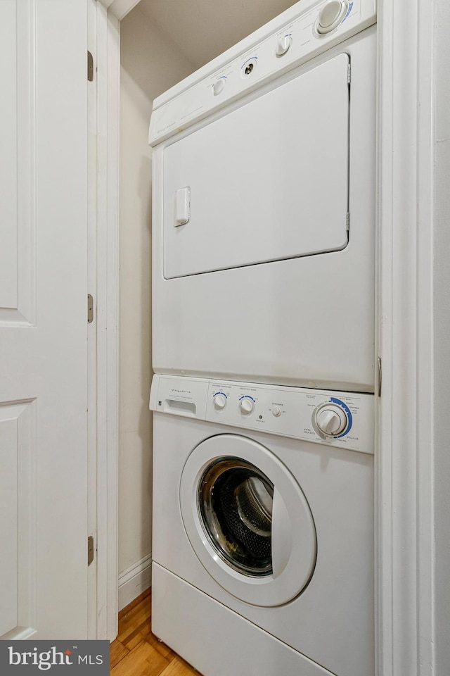 3318 Sherman Ave NW Unit 104, Washington, DC 20010 - washroom with stacked washing machine and dryer, light wood-style floors, and baseboards