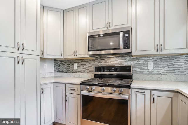13704 Beret Pl, Silver Spring, MD 20906 - kitchen featuring appliances with stainless steel finishes, decorative backsplash, and light stone countertops
