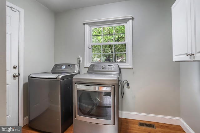 13704 Beret Pl, Silver Spring, MD 20906 - washroom featuring cabinet space, separate washer and dryer, baseboards, and wood finished floors
