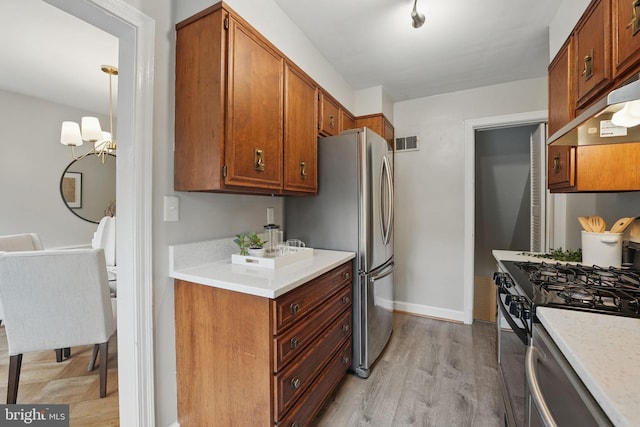 711 Avon Pl, Alexandria, VA 22314 - kitchen featuring black gas stove, freestanding refrigerator, light countertops, brown cabinetry, and a chandelier