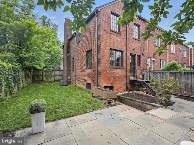 711 Avon Pl, Alexandria, VA 22314 - view of home's exterior with central AC, a chimney, brick siding, and a patio