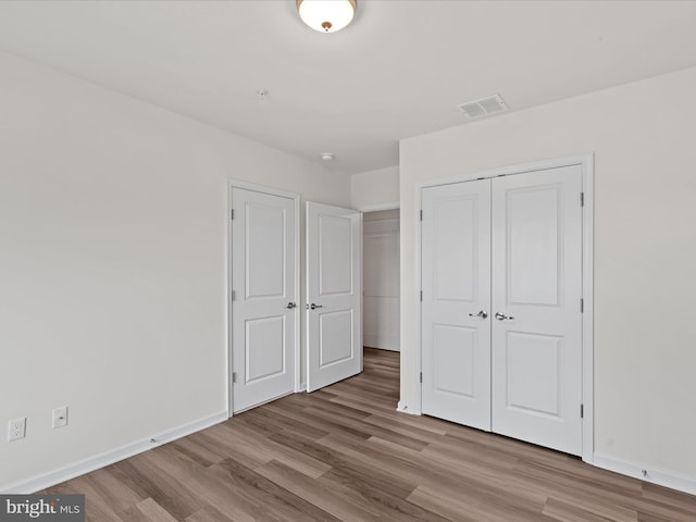 24258 Zinfandel Ln Unit R303, Lewes, DE 19958 - unfurnished bedroom with wood finished floors, a closet, and baseboards