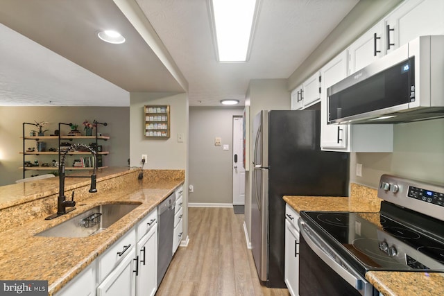 1328 Greenbriar Cir Unit 5-1328, Baltimore, MD 21208 - kitchen featuring appliances with stainless steel finishes, light wood-style flooring, white cabinets, baseboards, and recessed lighting