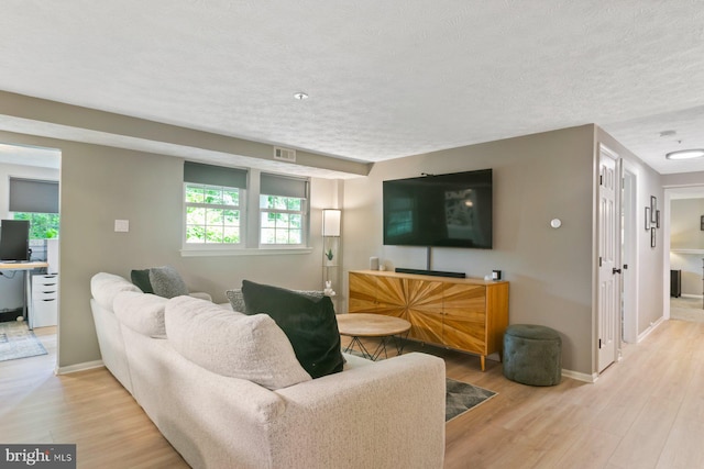 1328 Greenbriar Cir Unit 5-1328, Baltimore, MD 21208 - living room with light wood-style flooring, a textured ceiling, and baseboards