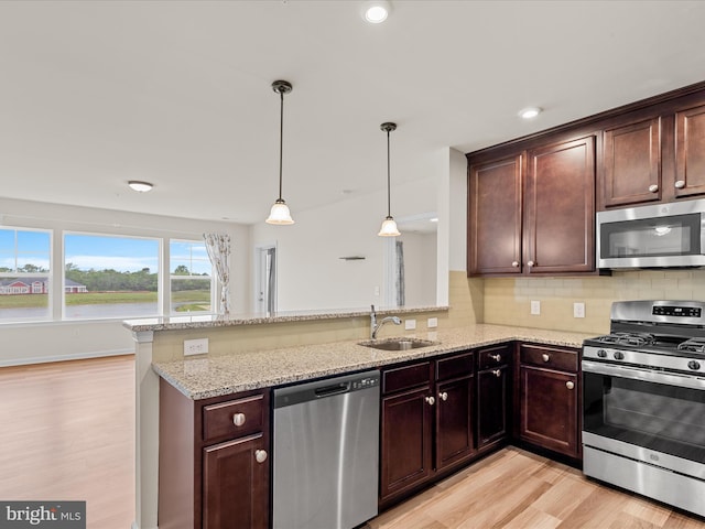 24238 Zinfandel Ln Unit R307, Lewes, DE 19958 - kitchen featuring appliances with stainless steel finishes, a sink, light wood-type flooring, a peninsula, and backsplash