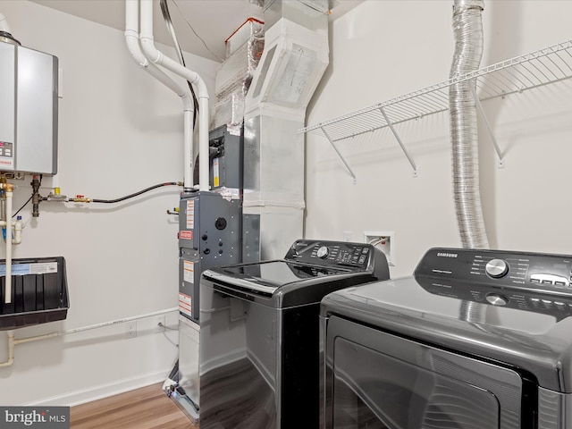 24238 Zinfandel Ln Unit R307, Lewes, DE 19958 - laundry area featuring washing machine and clothes dryer, tankless water heater, wood finished floors, and baseboards
