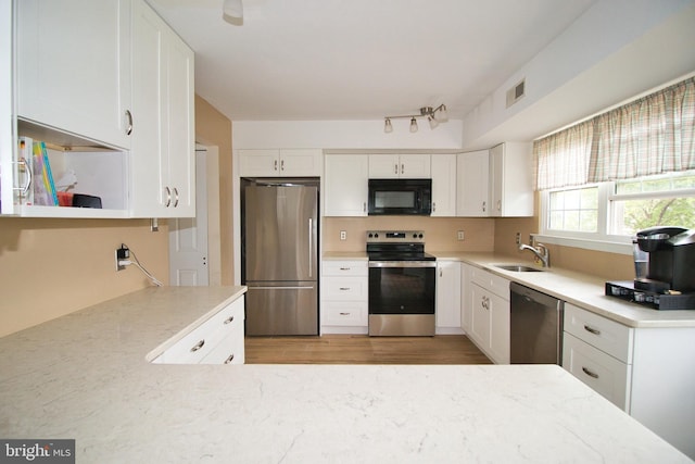 113 Megan Cir, Chalfont, PA 18914 - kitchen featuring appliances with stainless steel finishes, a sink, white cabinets, light stone counters, and light wood-style flooring