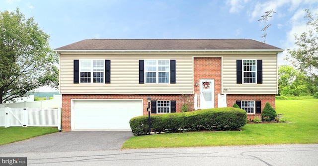 218 Independence Ave, State College, PA 16801 - raised ranch featuring brick siding, a garage, asphalt driveway, and a gate