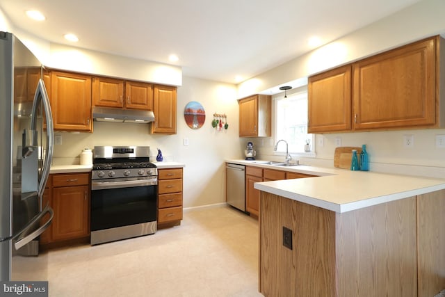 218 Independence Ave, State College, PA 16801 - kitchen with stainless steel appliances, under cabinet range hood, a sink, a peninsula, and brown cabinetry