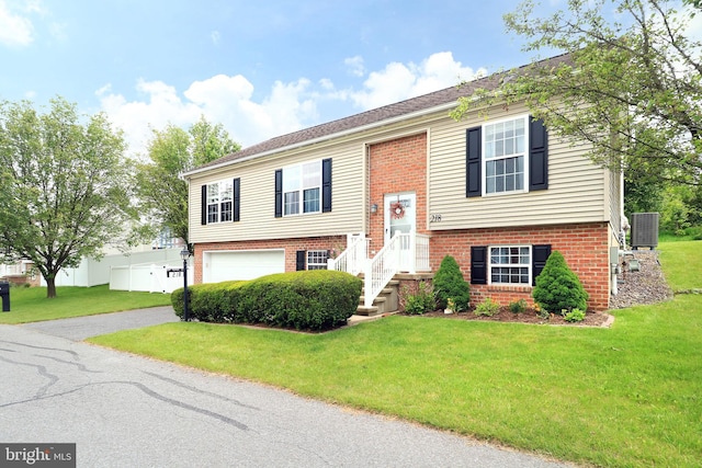 218 Independence Ave, State College, PA 16801 - raised ranch featuring brick siding, asphalt driveway, a front lawn, a garage, and cooling unit