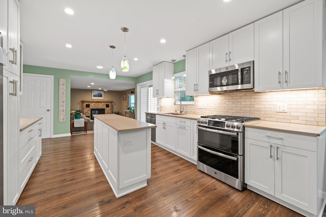 84 Winding Way, Upper Chichester, PA 19061 - kitchen featuring appliances with stainless steel finishes, a sink, decorative backsplash, a center island, and white cabinets