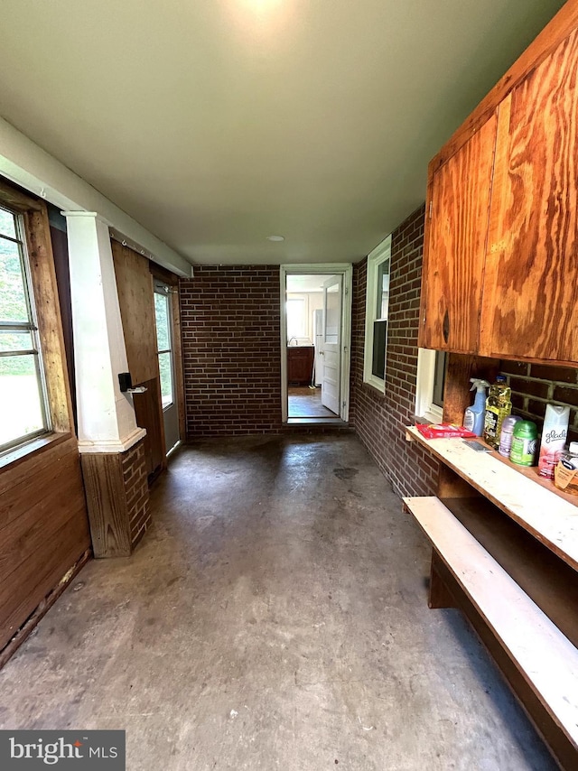 4599 Carlisle Rd, Gardners, PA 17324 - kitchen with concrete floors, brick wall, and brown cabinetry