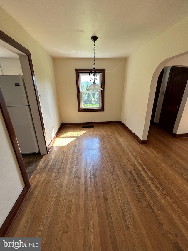 4599 Carlisle Rd, Gardners, PA 17324 - unfurnished dining area with arched walkways, wood finished floors, and baseboards