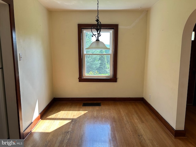 4599 Carlisle Rd, Gardners, PA 17324 - unfurnished dining area with arched walkways, wood-type flooring, and baseboards